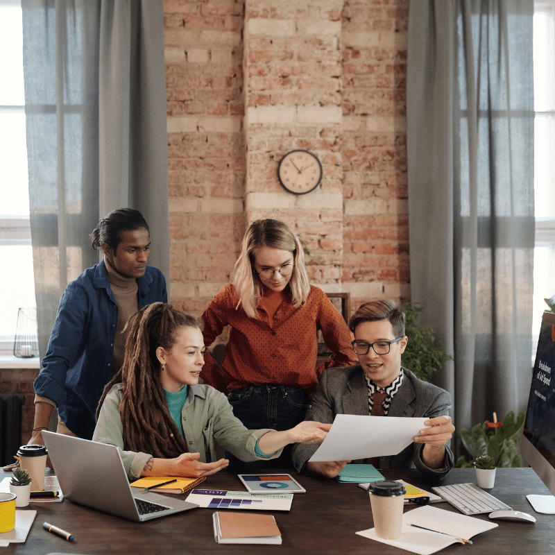 A team of Arizona SEO experts collaborating in a modern office with computers displaying analytics.